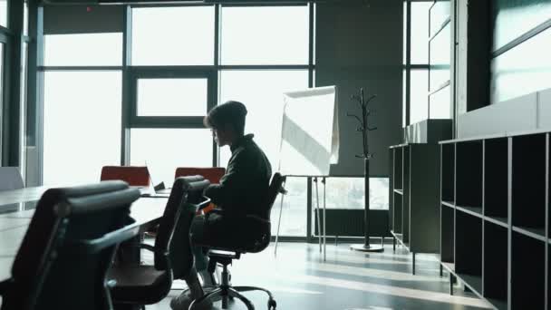 戴眼镜的布鲁内亚洲男人在一个共同工作的房间里的书桌上工作 — 图库视频影像