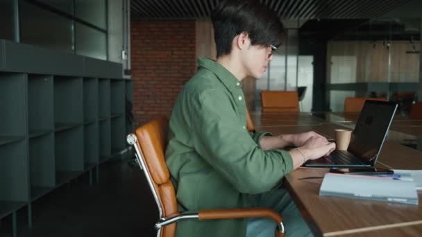 Hombre Asiático Concentrado Anteojos Mensajes Texto Ordenador Portátil Oficina — Vídeos de Stock