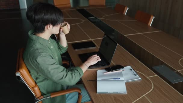Bonito Homem Asiático Óculos Mensagens Texto Laptop Beber Café Escritório — Vídeo de Stock