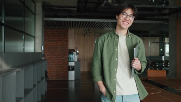 Sonriente Hombre Asiático Gafas Mirando Cámara Una Sala Trabajo — Vídeo de stock