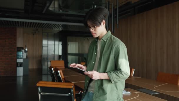 Hombre Asiático Concentrado Gafas Que Trabajan Tableta Mirando Ventana Una — Vídeo de stock