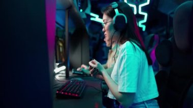 Konsantre Asyalı kadın oyuncu şampiyonada RPG oyunu oynuyor. Stil Neon Sanal Oyunları