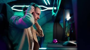Serious long haired man gamer starts to play RPG video game on a championship. Stylish Neon Cyber Games