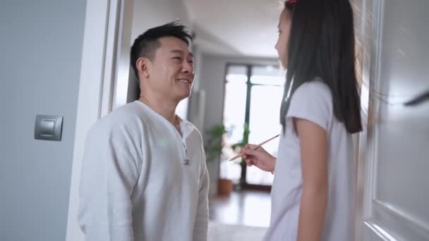Улыбающаяся Азиатская Дочь Измеряет Рост Своего Отца Дома — стоковое видео
