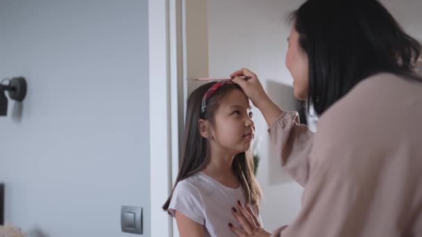 Cute Asian Mom Measures Her Daughter Height Home — Stock Video