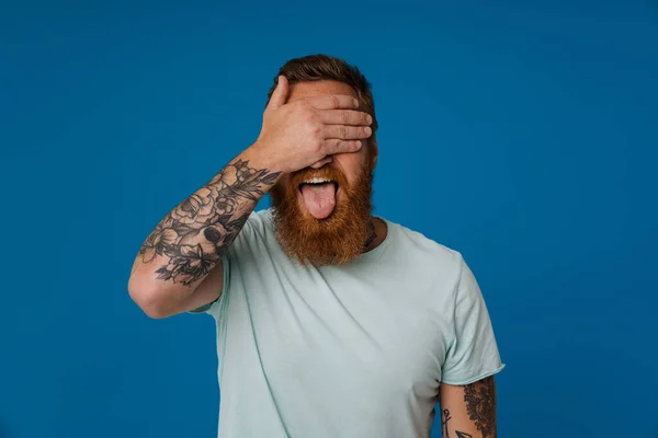 Retrato Adulto Barbudo Tatuado Homem Mostrando Língua Cobrindo Olhos Com — Fotografia de Stock