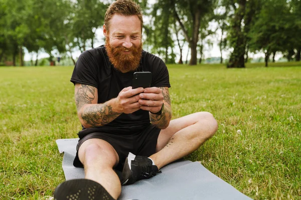 Ginger Barbudo Homem Usando Celular Durante Prática Ioga Parque Livre — Fotografia de Stock