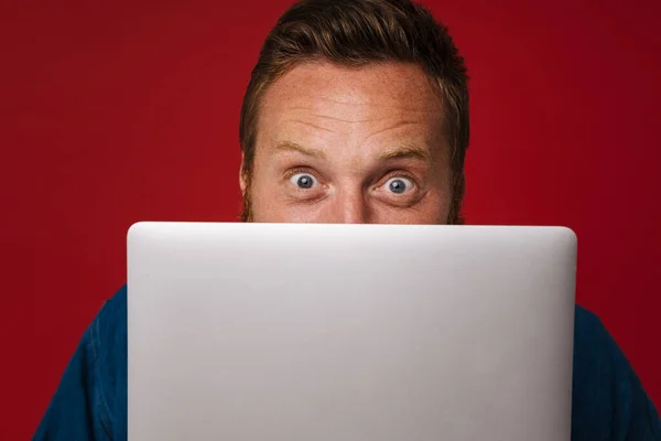 Ginger Shocked Man Wearing Denim Shirt Posing Laptop Isolated Red — Stock Photo, Image