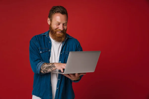 Ginger Biały Człowiek Dżinsowej Koszuli Uśmiecha Się Pomocą Laptopa Izolowane — Zdjęcie stockowe