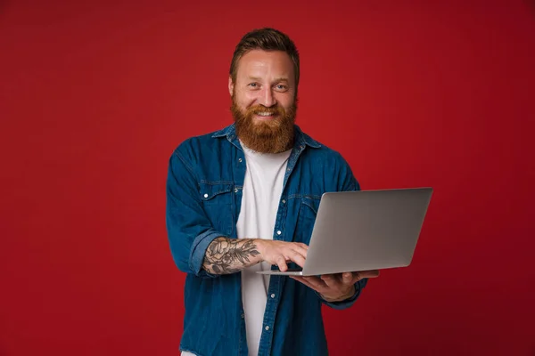 Ginger Biały Człowiek Dżinsowej Koszuli Uśmiecha Się Pomocą Laptopa Izolowane — Zdjęcie stockowe