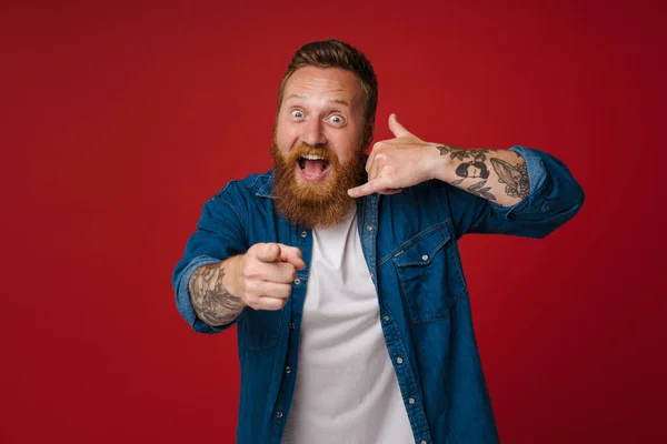 Ginger Excited Man Smiling While Making Handset Gesture Isolated Red — Stock Photo, Image