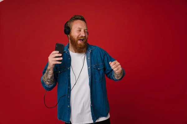 Kızıl Beyaz Adam Kırmızı Arka Planda Izole Edilmiş Müzik Dinlerken — Stok fotoğraf