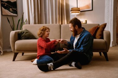 Heyecanlı mutlu baba ve oğul evdeki rahat oturma odasında otururken birlikte eğleniyorlar.