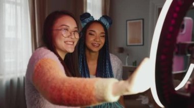 Çok uluslu kadın blogcular evdeki telefon kameralarına video kaydediyor.