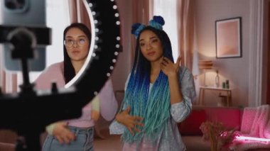 Çok uluslu kadın blogcular evde dans edip şarkı söylüyorlar.