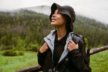 Sırt çantalı, sırtüstü dağlarda yürürken gözlerini kaçıran Afrikalı genç bir turist.