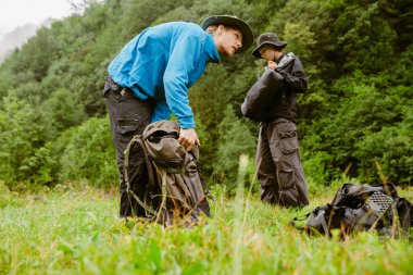 Genç beyazlar dağ ormanlarında yürüyüş yaparken sırt çantalarını kullanarak yürüyüş ekipmanı kullanıyorlar.