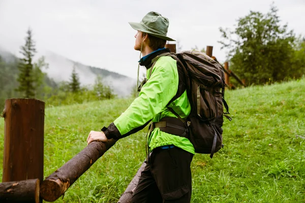 Młody Biały Człowiek Turysta Plecakiem Stojący Pobliżu Drewnianego Ogrodzenia Odwracając — Zdjęcie stockowe