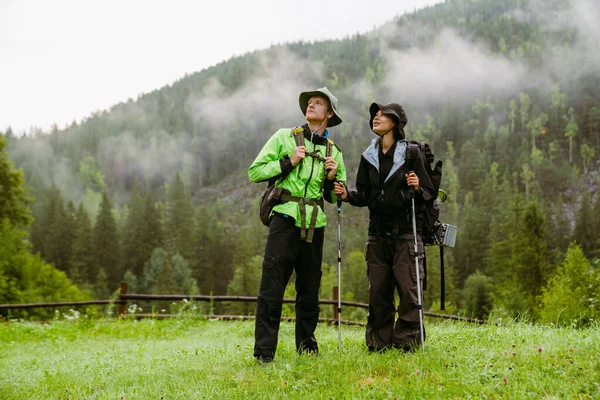 年轻的多族裔游客夫妇 背着背包在山上远足 — 图库照片