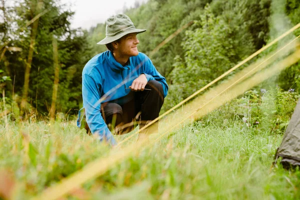 Młody Biały Turysta Siedzi Trawie Podczas Wędrówki Górskim Lesie — Zdjęcie stockowe