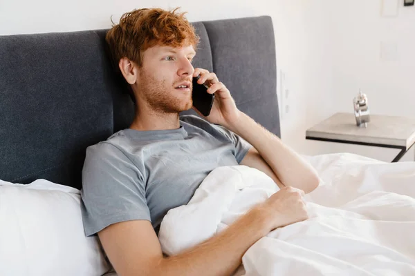 Gri Tişörtlü Genç Kızıl Saçlı Telefonda Konuşan Yan Bakan Evde — Stok fotoğraf