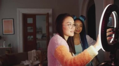 İki çok uluslu kadın blogcu bir şey hakkında konuşuyor ve evde telefona bakıyor.