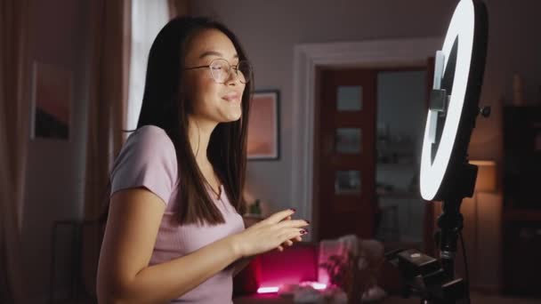 可愛いですアジアのブルネット女性ブロガーポーズと上のカメラ電話にホーム — ストック動画