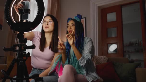 積極的な多民族の女性ブロガーが話していると自宅でカメラの携帯電話にポーズ — ストック動画