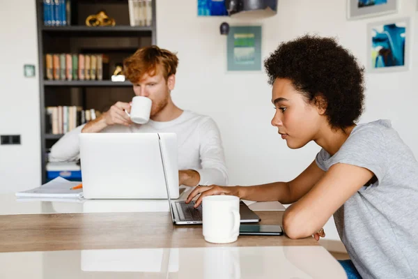 Genç Çift Evde Dizüstü Bilgisayar Kullanırken Kahve Içiyor — Stok fotoğraf