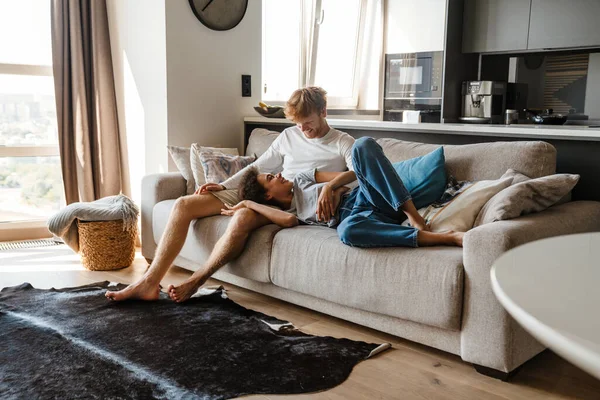 Jeune Couple Multinational Joyeux Étreignant Tout Reposant Sur Canapé Maison — Photo