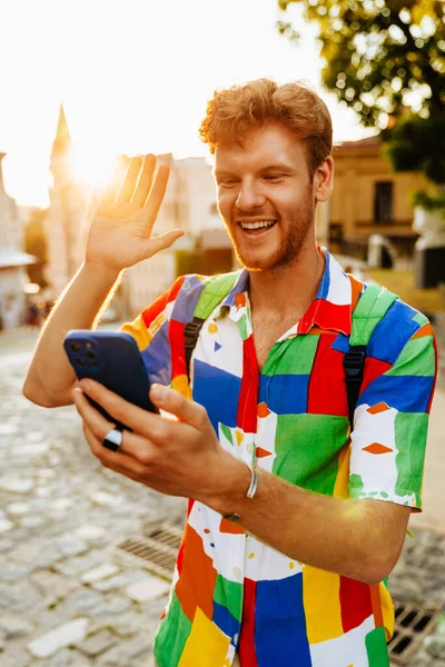 Mladý Pohledný Usměvavý Zrzka Muž Telefonem Držení Videokonference Mávání Zatímco — Stock fotografie