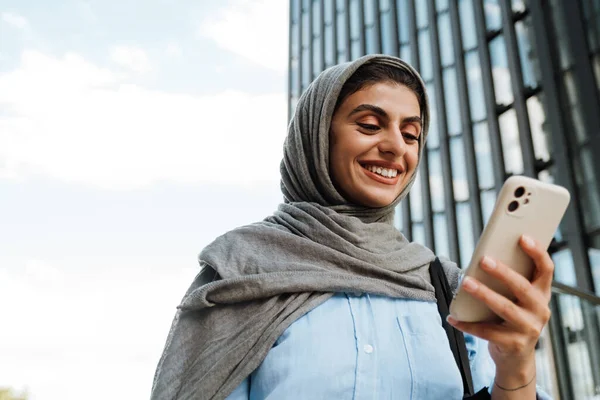 Mulher Muçulmana Sorrindo Usando Lenço Cabeça Usando Smartphone Enquanto Estava — Fotografia de Stock