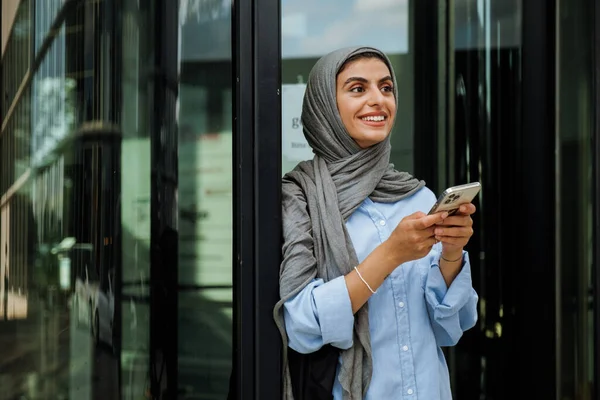 Mulher Muçulmana Meia Idade Alegre Usando Hijab Usando Telefone Enquanto — Fotografia de Stock