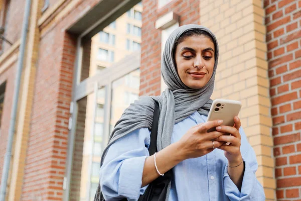 Mulher Muçulmana Sorridente Meia Idade Usando Hijab Usando Smartphone Enquanto — Fotografia de Stock