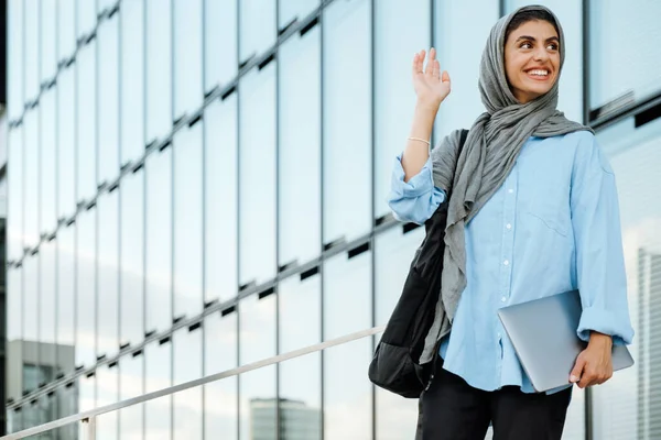 Νεαρή Μουσουλμάνα Γυναίκα Φορώντας Μαντίλα Κουνώντας Χέρι Ενώ Περπάτημα Φορητό — Φωτογραφία Αρχείου