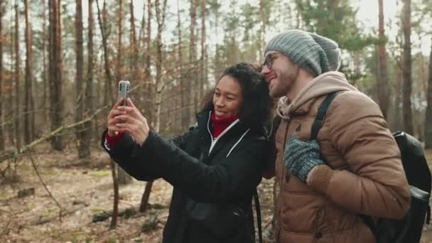 Довольно Многонациональная Туристическая Пара Разговаривает Видеосвязи Мобильном Телефоне Лесу — стоковое видео