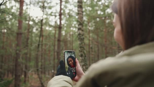 森の中で電話でビデオ通話で話す幸せな多国籍観光の友人 — ストック動画