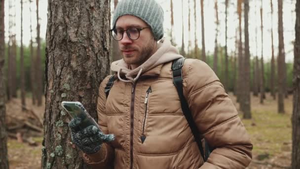 Positive Touristenmann Mit Hut Sms Auf Handy Während Sie Neben — Stockvideo