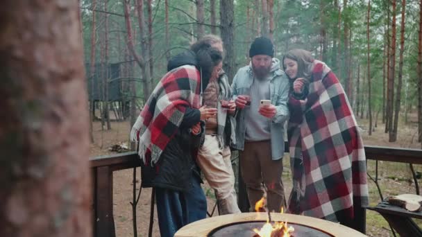 Glückliche Multinationale Freunde Die Lagerfeuer Mit Decken Bedeckt Wald Telefonieren — Stockvideo
