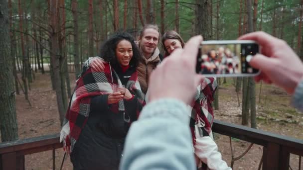 森の中で多国籍の友人の電話で写真を撮る男 — ストック動画