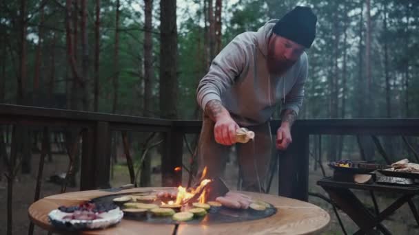 Homem Barbudo Concentrado Fritando Salsichas Com Abobrinha Fogo Floresta — Vídeo de Stock