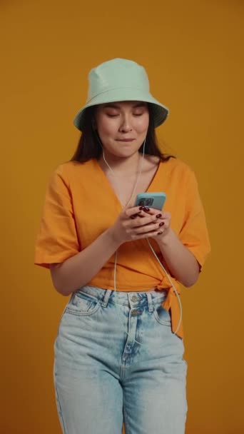Uvolněná Asijská Žena Nosí Panama Klobouk Poslech Hudby Sluchátkách Mobilu — Stock video
