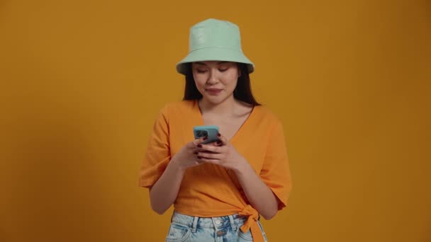 Smilende Asiatisk Kvinne Med Panamahatt Mobil Seg Rundt Det Gule – stockvideo