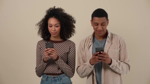 Positiva Pareja Joven Africana Escribiendo Los Teléfonos Mientras Está Pie — Vídeos de Stock