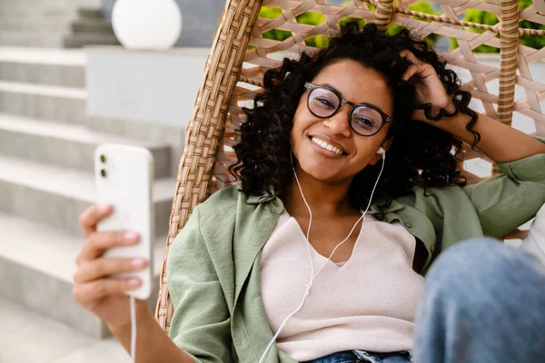 Joven Mujer Afroamericana Alegre Auriculares Usando Teléfono Inteligente Mientras Está —  Fotos de Stock