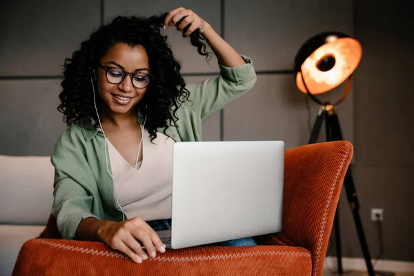 Gözlüklü Neşeli Afrikalı Kadın Evde Otururken Dizüstü Bilgisayarla Çalışıyor — Stok fotoğraf