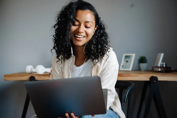 Schwarze Junge Frau Lächelt Und Arbeitet Mit Laptop Während Sie — Stockfoto