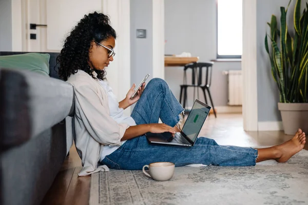 Black Young Woman Using Gadgets Drinking Coffee While Sitting Floor — Stock Photo, Image