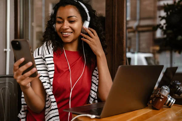 Junge Schwarze Frau Mit Kopfhörer Benutzt Laptop Und Handy Während — Stockfoto