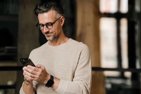 Middle Aged White Man Eyeglasses Smiling While Using Smartphone Indoors — Stock Photo, Image